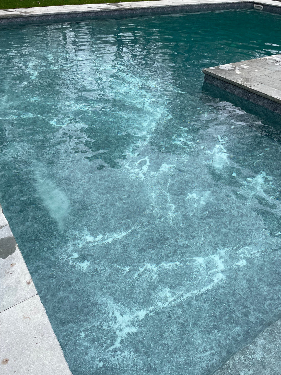 Clear blue swimming pool with custom plumbing lines during a spring opening and salt system startup.