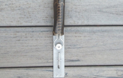 A genuine Loop-Loc stainless steel spring with a vinyl protector installed on a Deck-Loc anchor for a composite pool deck.
