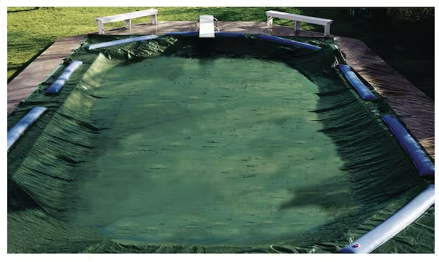 Green Swimline Supreme Guard solid pool cover installed on a rectangular 16x32 inground swimming pool.